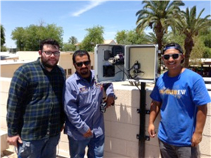 Three men stand in front of an air monitor that they installed in Imperial County, CA.
