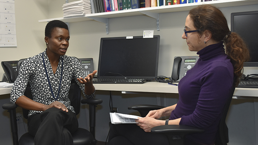 Dr. Esi Nkyekyer discusses patient care with a medical fellow.
