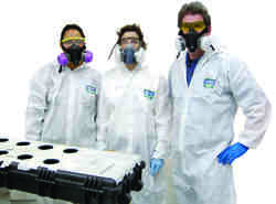 Exposure Science students modelling personal protective equipment and a device to test glove efficacy. Photo courtesy of Diana Ceballos.