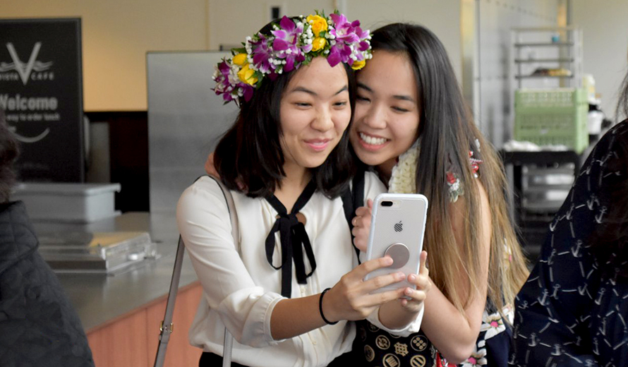 Two students take a selfie at the DEOHS graduation reception.