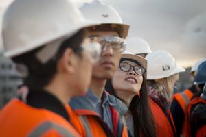 Students in hard hats and reflective vests are lined up. Students in hard hats and reflective vests are lined up.
