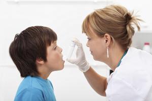 Photo: ilona75/iStock/Thinkstock Health practitioner administers an inhaler to a child