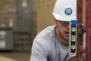 Costruction worker using a level. Costruction worker using a level.