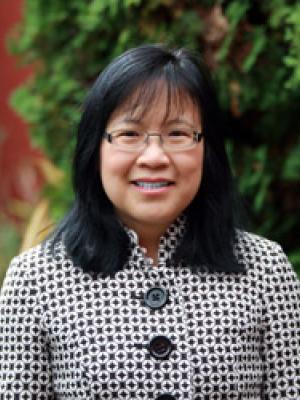 Dr Mar, a middle-aged Asian woman with shoulder length hair and fringe, with clear glasses
