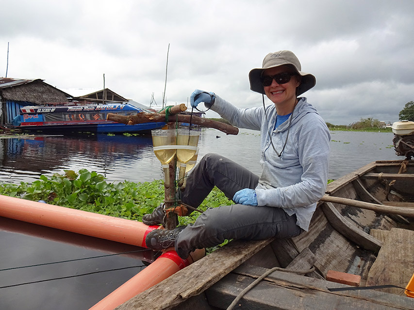 Dr. Rebecca Neumann collects water samples near a floating community in the Peruvian Amazon.