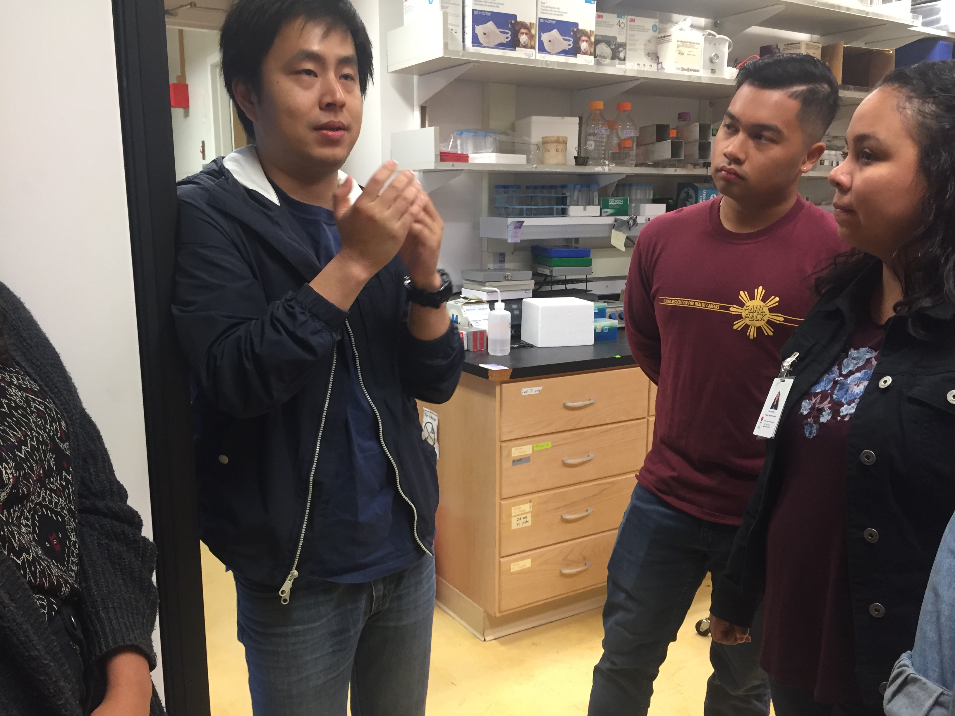 Graduate student, Hao Wang, discusses his research with visiting students in the Xia lab.