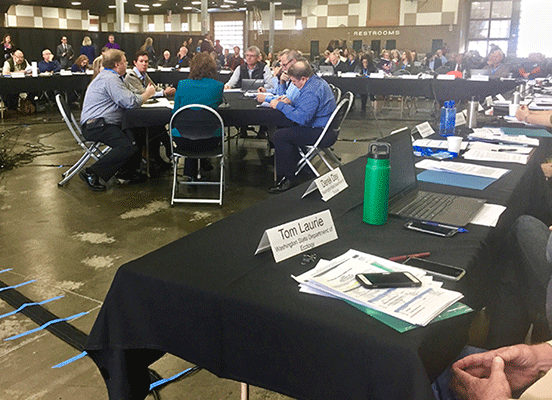 Members of Governor Inslee's Orca Recovery Task Force meet in a large exposition hall.
