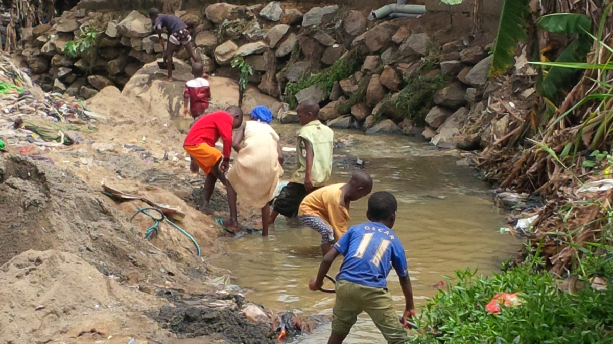 Children in Nigeria playing in water in a drainage area contaminated by wastewater.