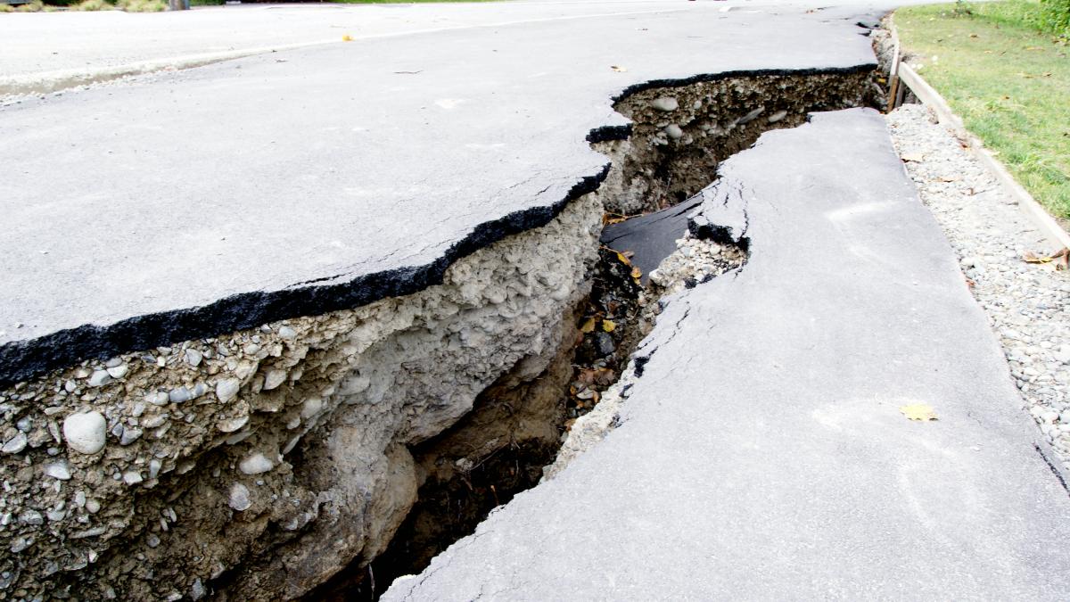 A thick, deep crack in an asphalt road caused by an earthquake. 