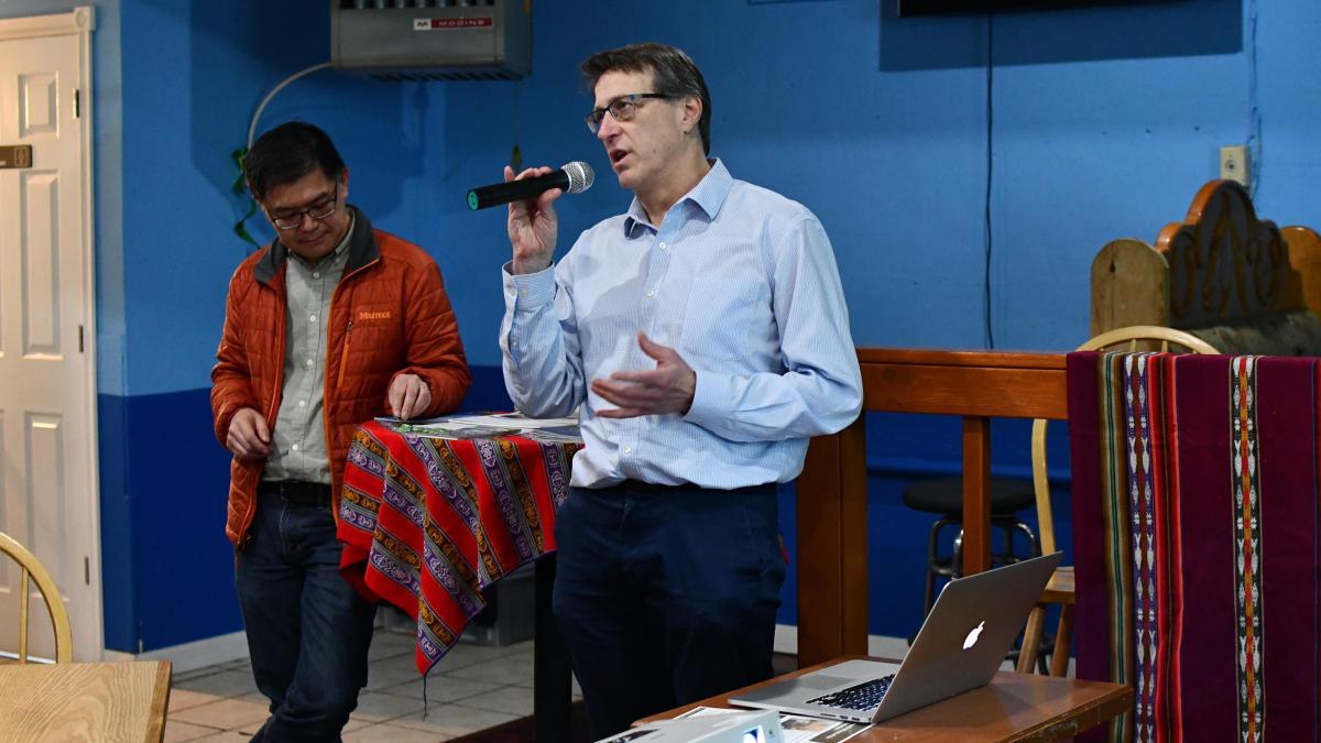 EDGE Director, Joel Kaufman, speaks with a microphone in a Mexican restaurant with blue walls