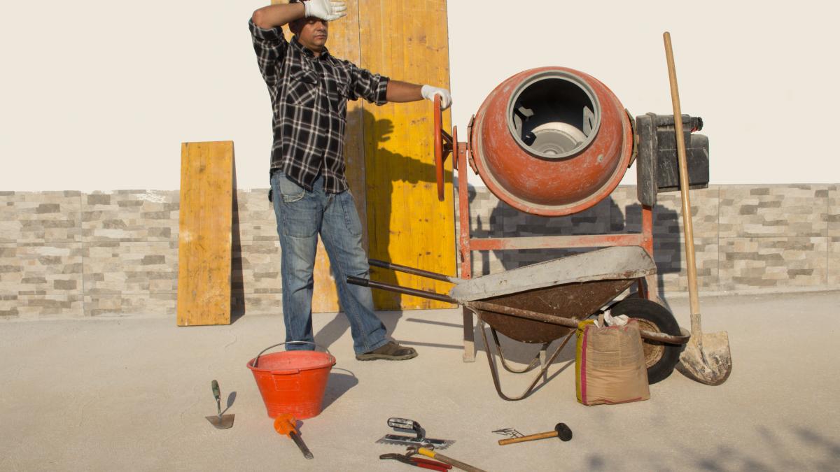 construction worker wiping their brow at worksite