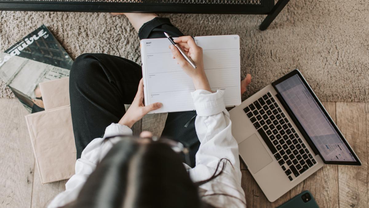 faceless lady with notebook and laptop at home