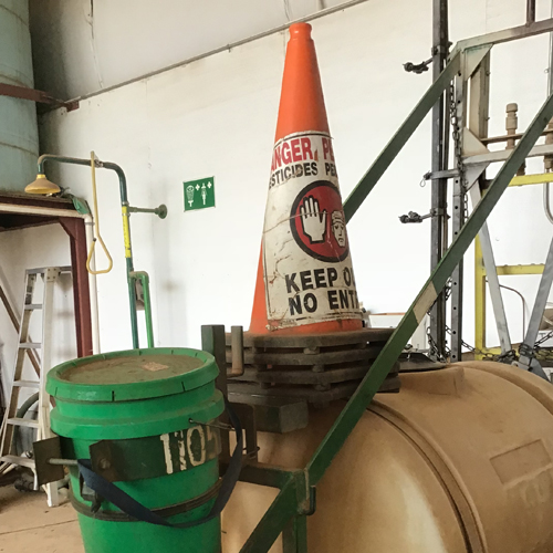 A pole stand on the back of the tank trailer holds cones for drop-off and pickup. 