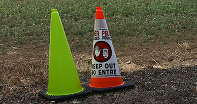 Orange cones for pesticide treated areas, and lime green cones for other hazards.