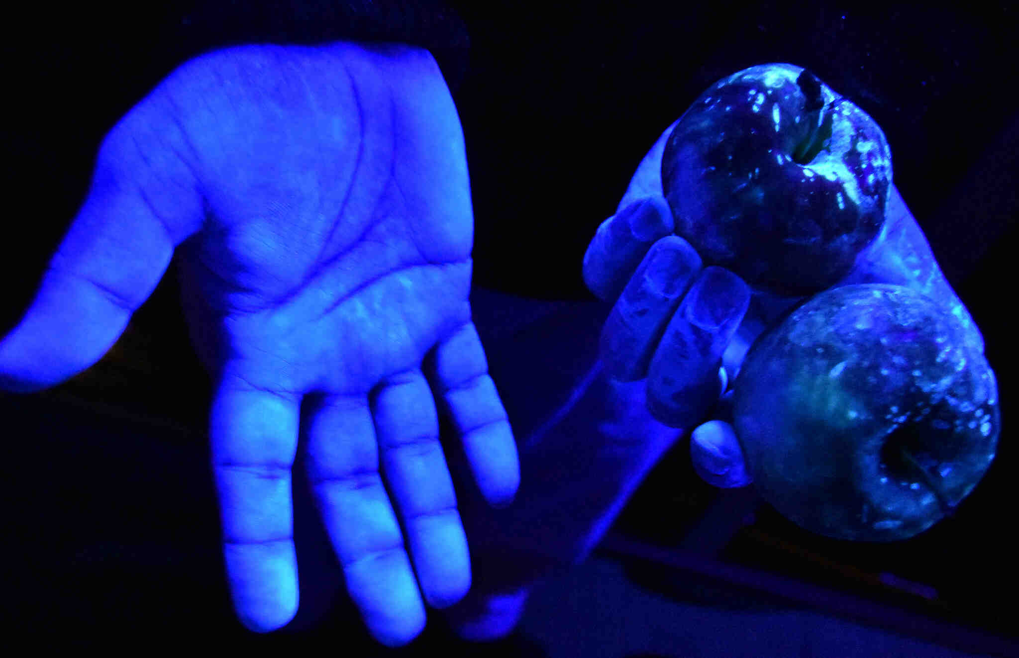image of hands glowing in fluorescent light