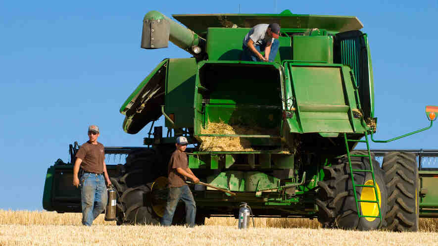 A harvest crew works quickly to contain a fire hazard from a malfunctioning combine in the Palouse area of Washington