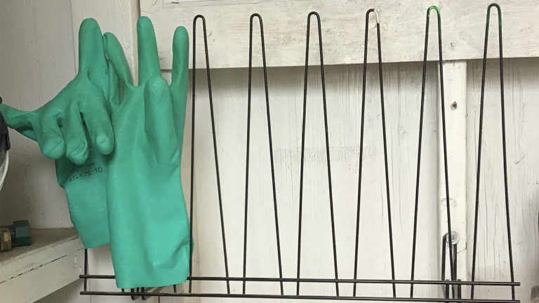 reusable gloves hanging on a metal rack