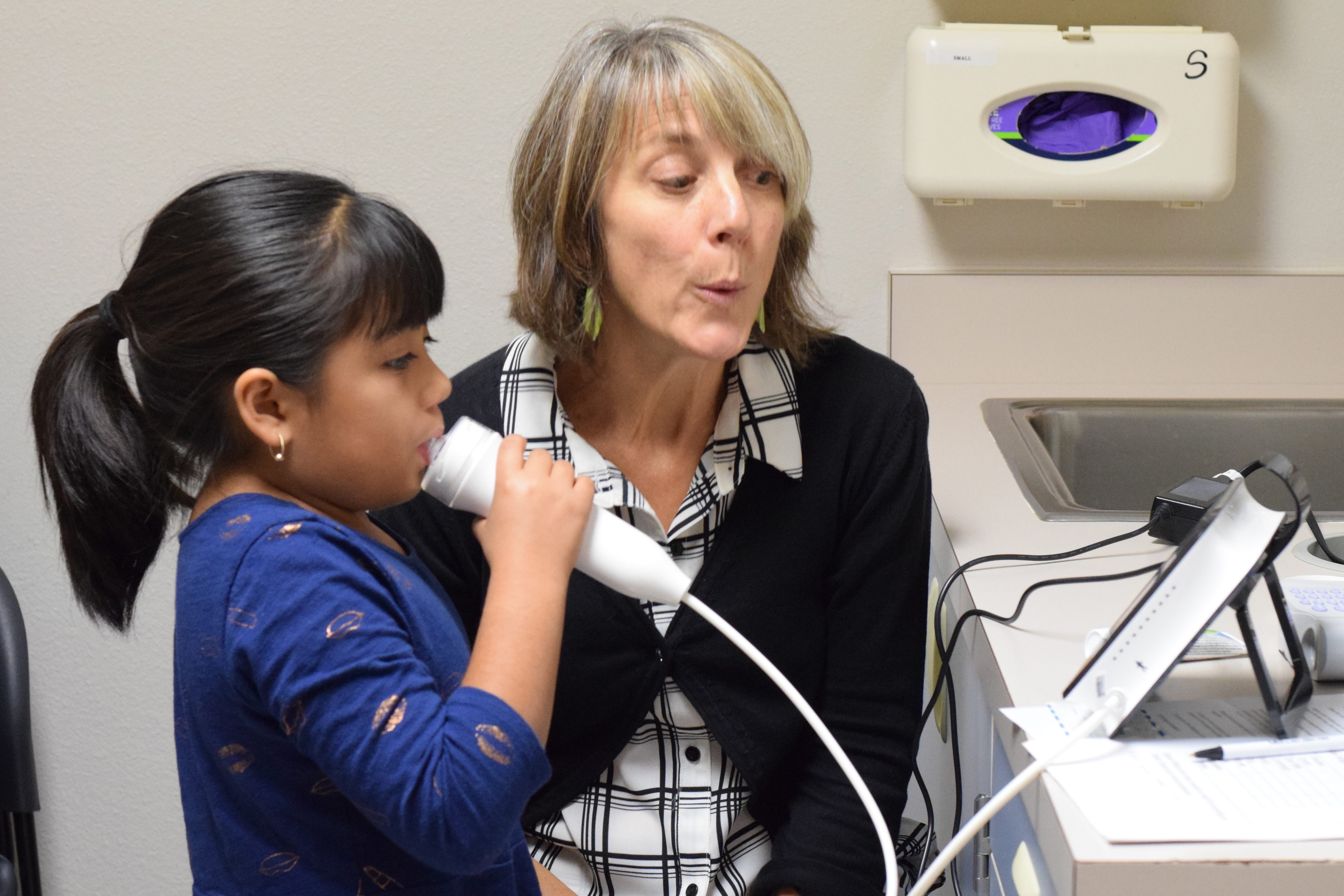 Dr. Catherine Karr works with a study participant to measure exhaled nitric oxide, a marker of lung inflammation.