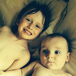 Young toddler and baby looking at camera