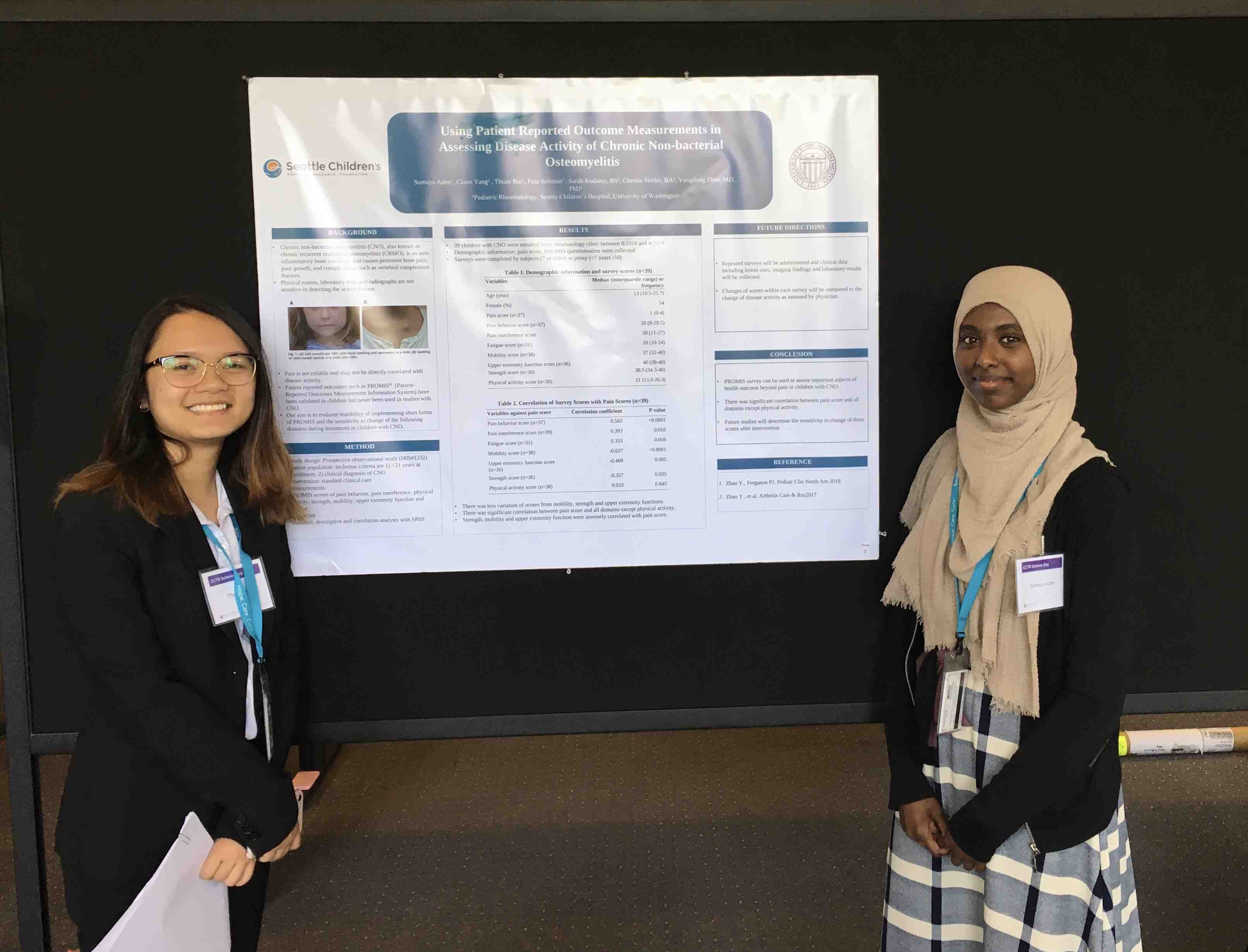 Two women stand in front of a research poster.