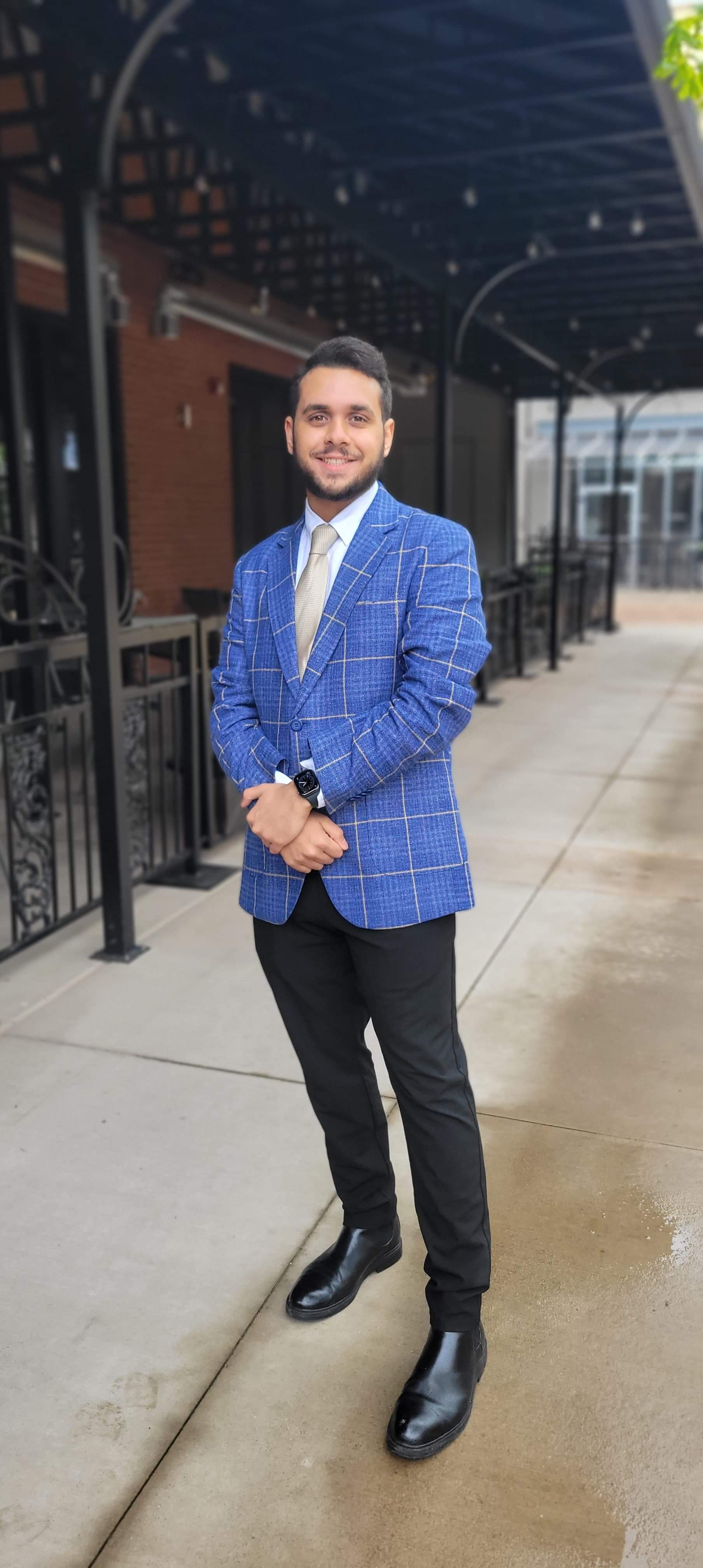 Malek smiling in a blazer