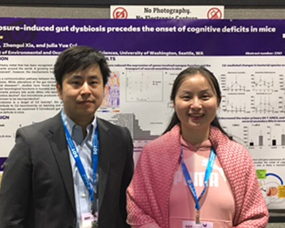 Hao Wang and Julia Cui stand in front of a research poster.