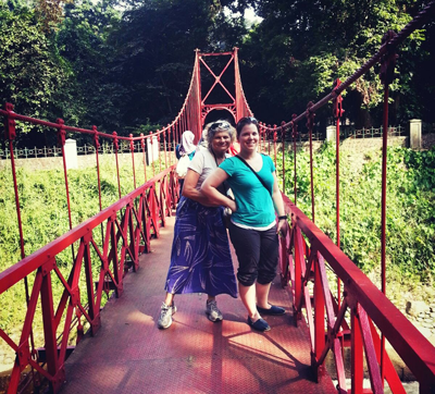 Photo of Professor Roberts and a student on a red pedestrian bridge.