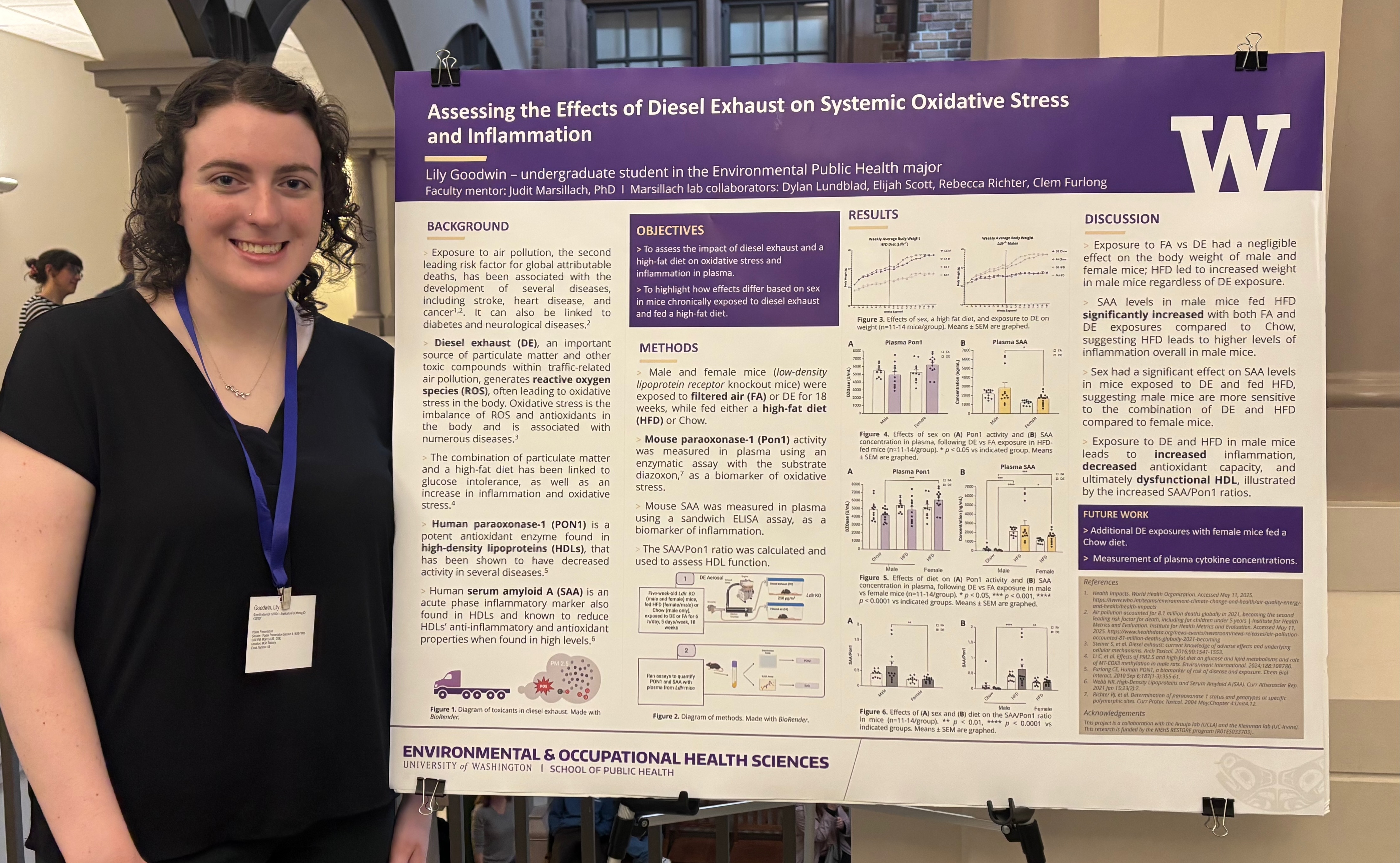 Lily Goodwin smiles standing next to a research poster.