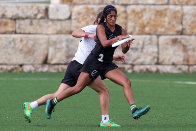 Yadama playing ultimate frisbee with an opponent behind her.