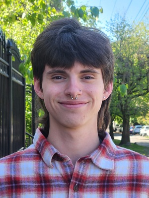 Person with brown hair wearing red plaid shirt