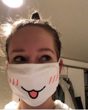 A woman wearing a face mask decorated with a dog mouth and whiskers.