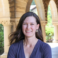 Headshot of Marissa Childs standing in a breezeway with stone arches behind her.