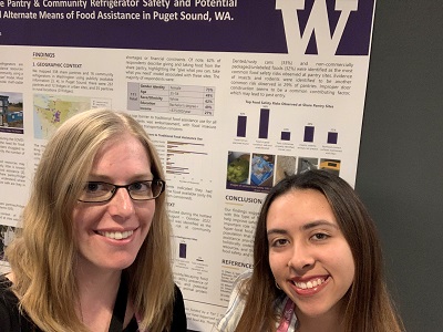 Tania Vallejo and Emily Hovis stand in front of a research poster.