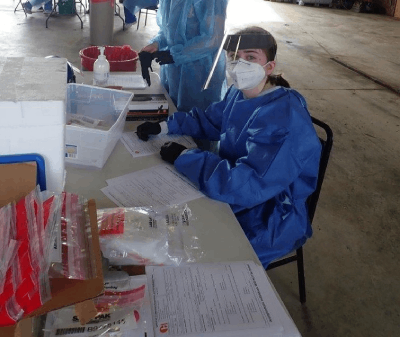 Peterson in personal protective equipment sitting at a COVID-19 testing center.