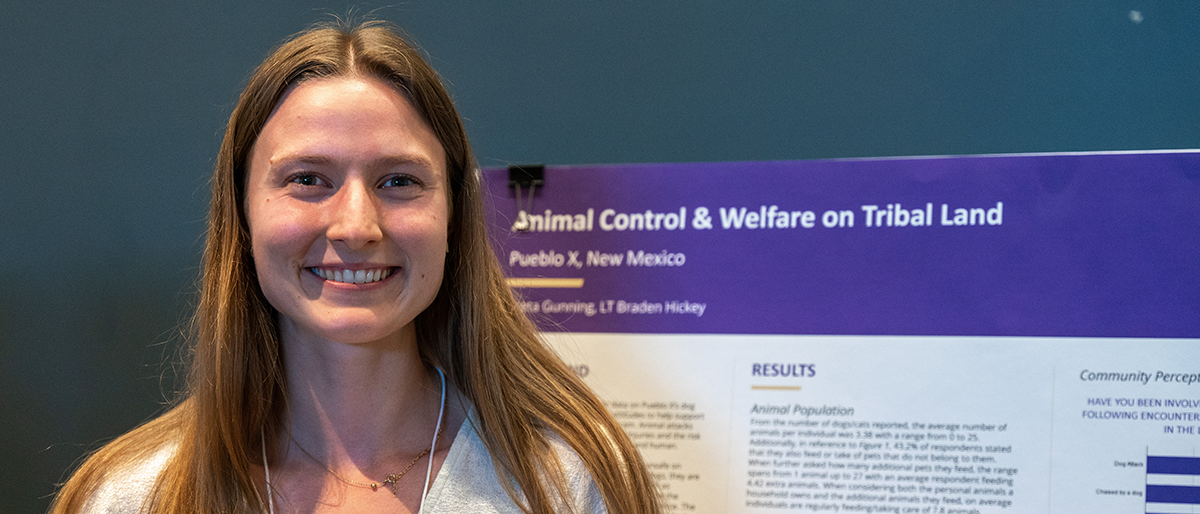 Photo of Greta Gunning in front of her poster at the symposium.