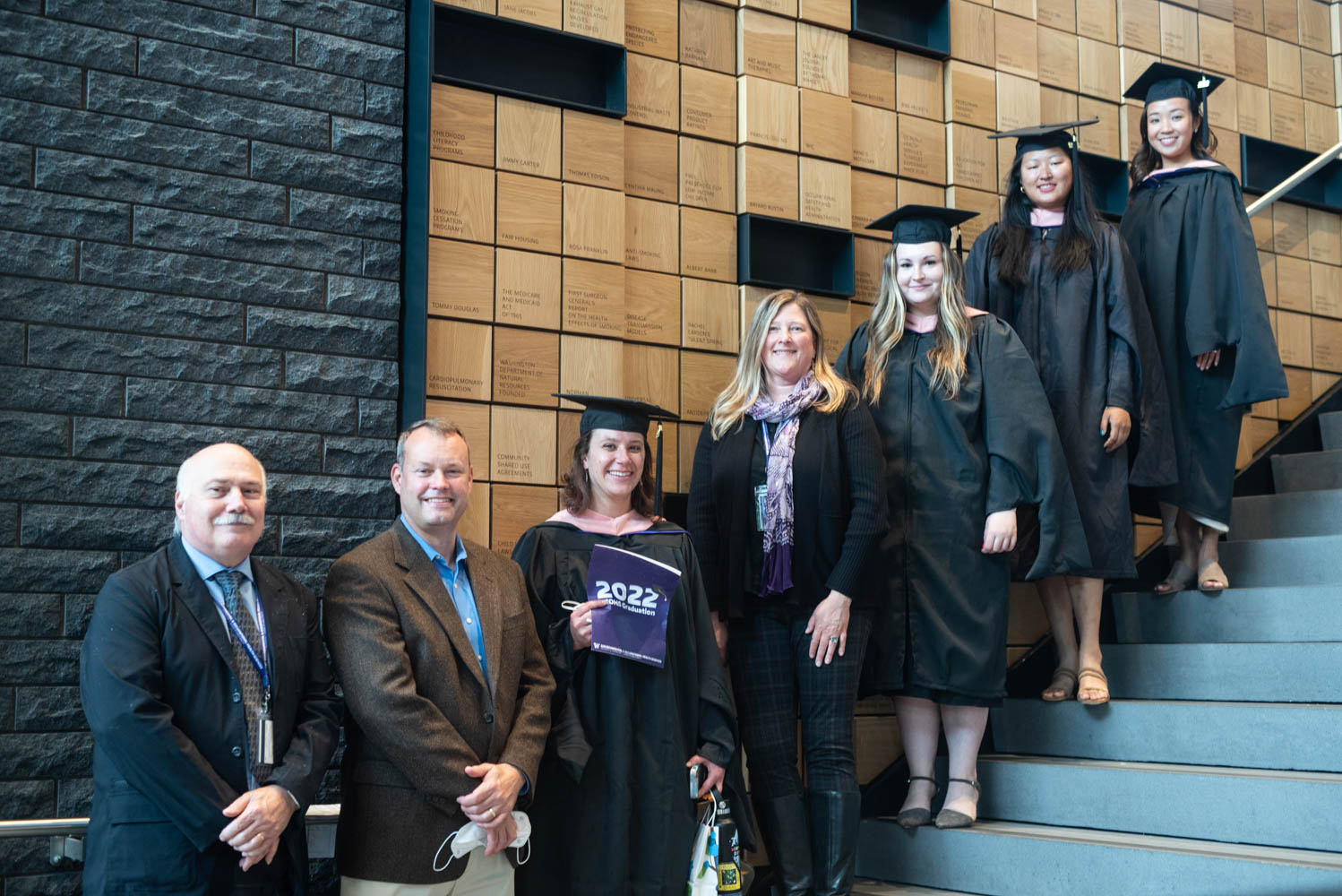 MPH graduates stand with DEOHS faculty on steps at the Hans Rosling Center for Population Health.