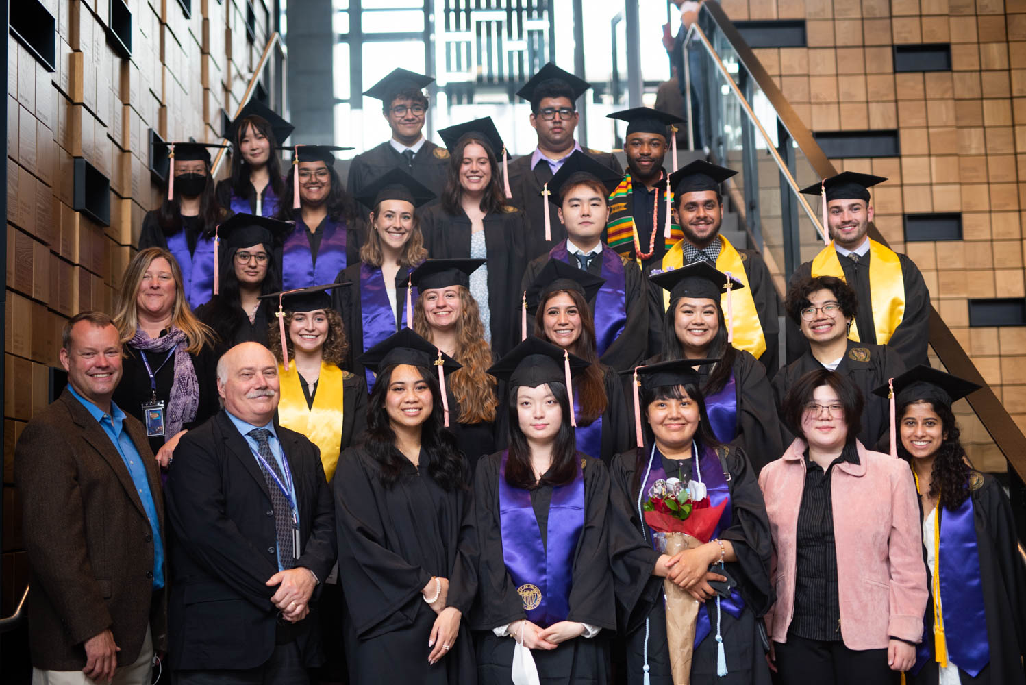 A group photo of DEOHS graduates standing on the steps of the Hans Rosling Center for Population Health.