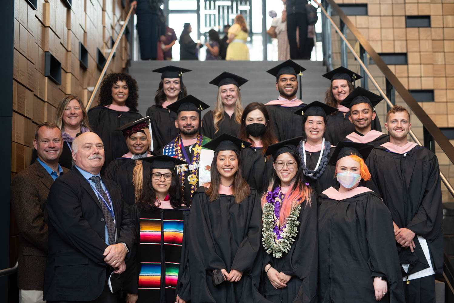 A group of MS graduates poses with DEOHS faculty members in the Hans Rosling Center for Population Health.