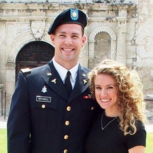 Man in military uniform, woman with long curly hair on right