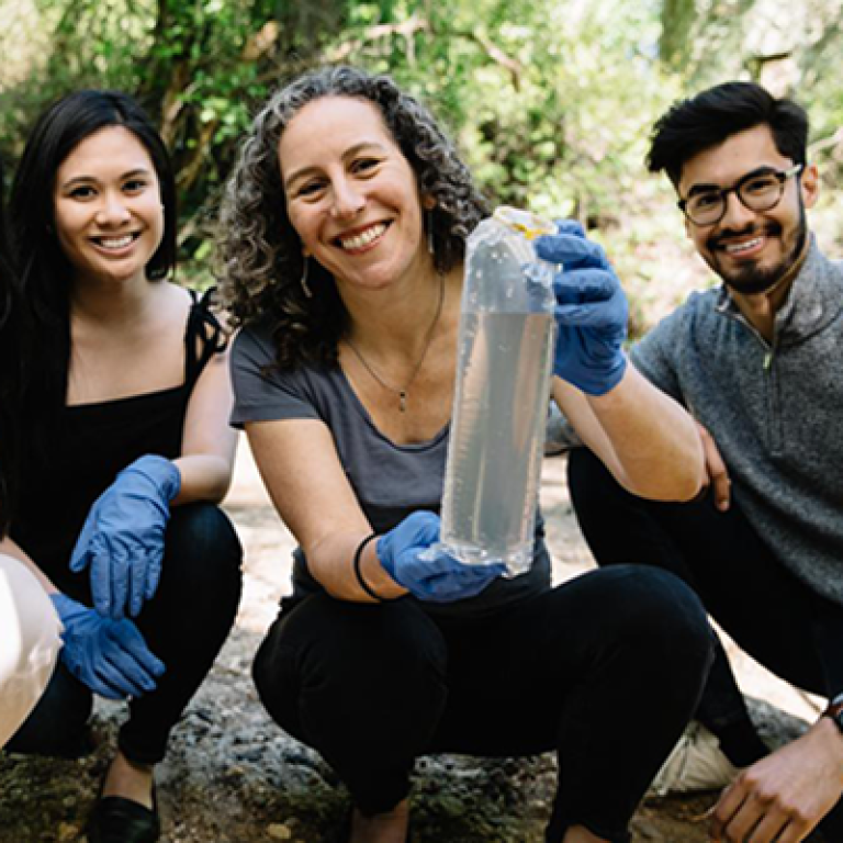 Karen with students showing a water sample