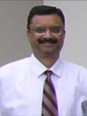 Dr Gautom, a middle-aged Indian man with short hair, glasses, and a mustache