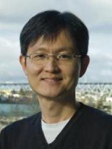 A thin middle-aged Asian man with clear framed glasses 