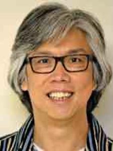 A middle-aged Asian man with long black and gray hair and black rectangular glasses