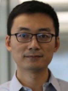 Dr Wang, a young Asian man with short hair and dark framed glasses