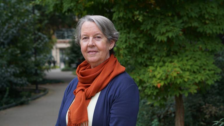 Lianne Sheppard stands on the UW campus with leafy trees in the background.