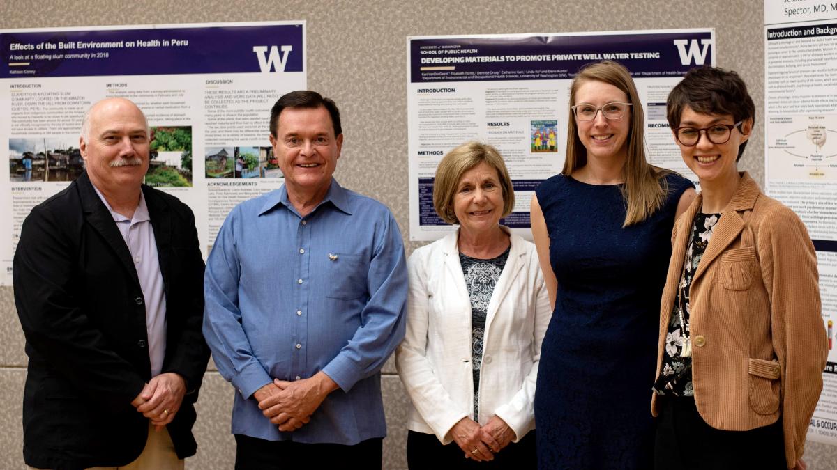 A group of people stand in front of research posters.