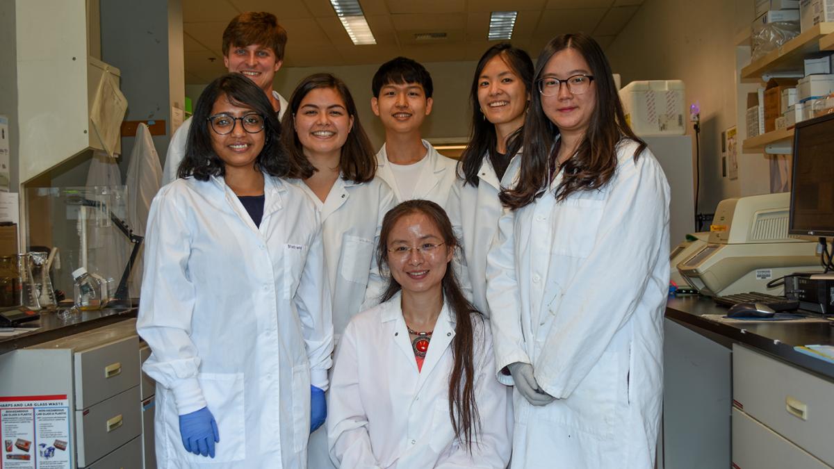 A team in labcoats poses in their lab.