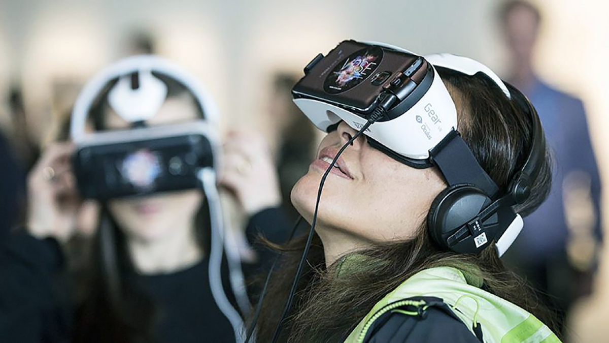 A woman looks through VR goggles.