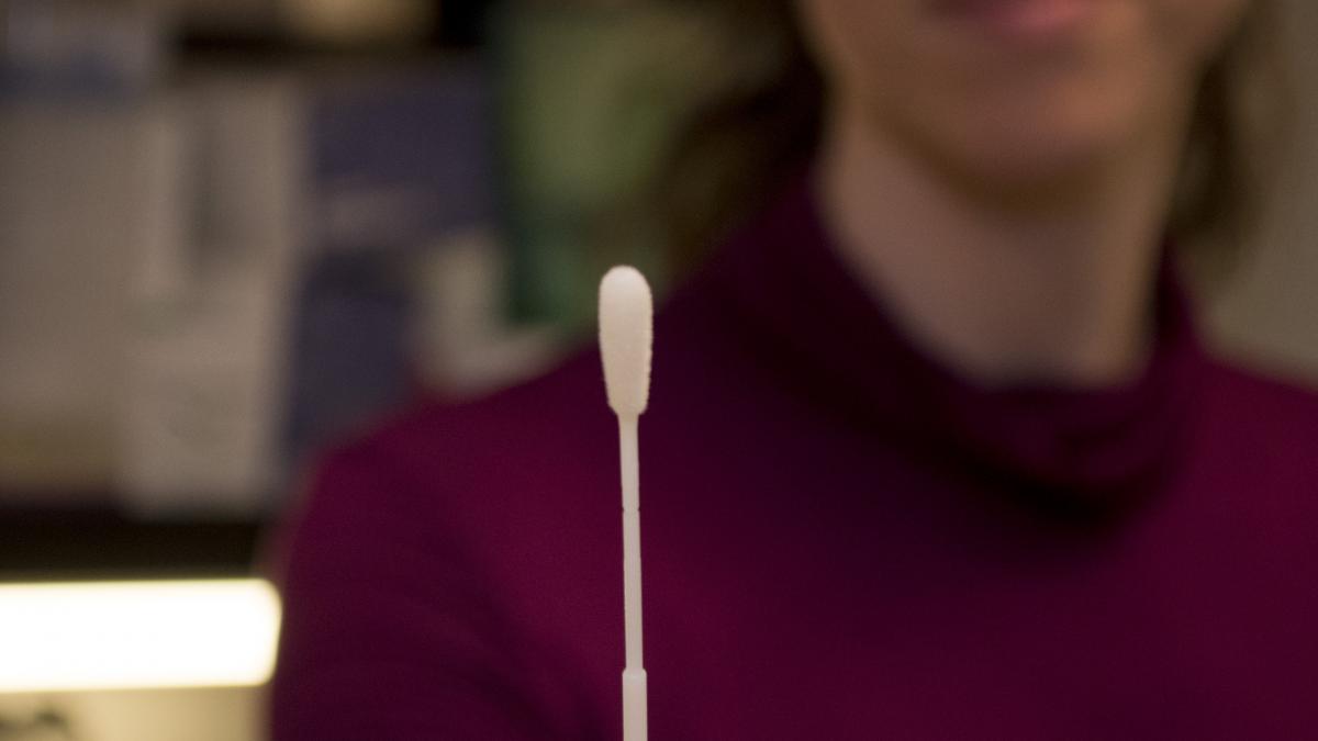 DEOHS research scientist Rachel Wood holds a cotton swab for TB testing.
