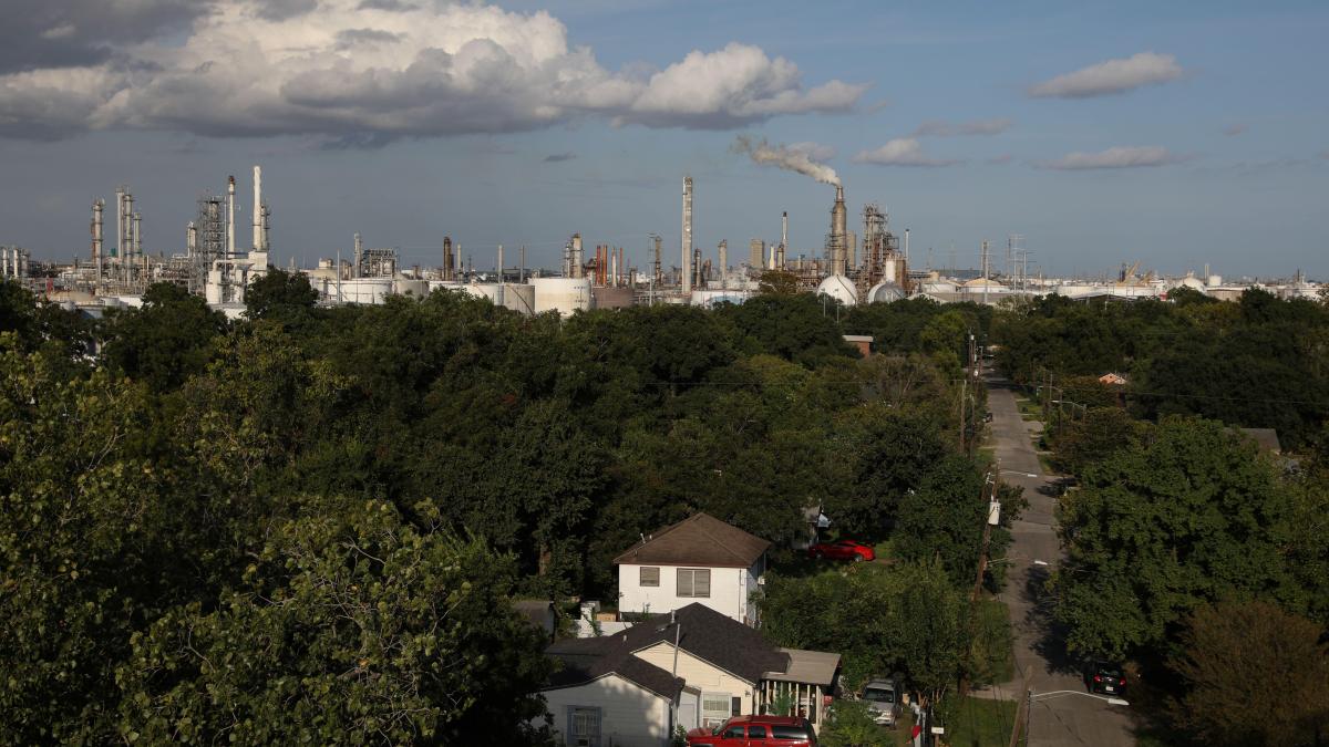A neighborhood in Houston showing houses with refineries in the background.